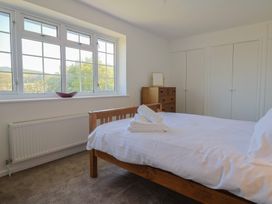 A bedroom with a bed and windows at Oakwood in Chideock