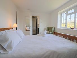 A bedroom with a bed and a chair at Oakwood in Chideock