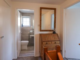 A bathroom with a toilet and mirror at Oakwood in Chideock