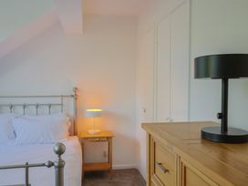 A bedroom with a bed and lamps at Oakwood in Chideock