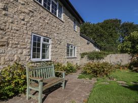 A garden with a stone wall and bench at Oakwood in Chideock