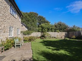 A garden with a bench and grass at Oakwood in Chideock