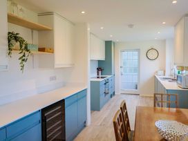 A kitchen with cabinets and a dining table at Oakwood in Chideock