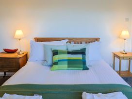 A bedroom with a bed and side tables at Oakwood in Chideock