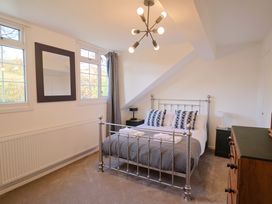 A bedroom with a bed and windows at Oakwood in Chideock