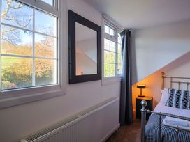 A bedroom with windows and a mirror at Oakwood in Chideock
