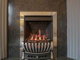 A fireplace with glowing coals at Gavin and Stacey House in Barry