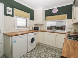 A kitchen with washing machine and microwave at Gavin and Stacey House in Barry