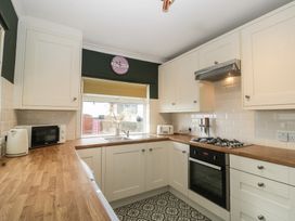 A kitchen with kitchen appliances and cabinets at Gavin and Stacey House in Barry