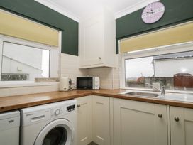 A laundry room with a washing machine and microwave at Gavin and Stacey House in Barry