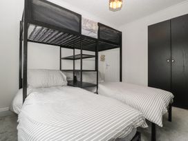 A bedroom with a bunk bed and a wardrobe at Gavin and Stacey House in Barry