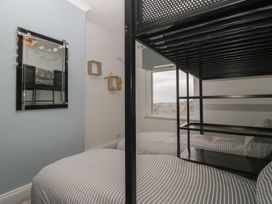 A bedroom with a bunk bed and a mirror at Gavin and Stacey House in Barry