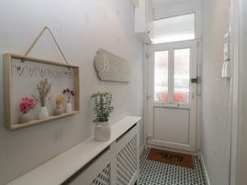 A hallway with a welcome sign and vases at Gavin and Stacey House in Barry