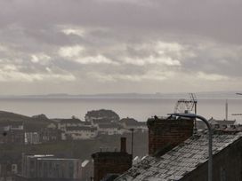 A view of the sea and buildings with a ferris wheel at Gavin and Stacey House in Barry