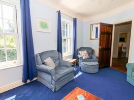 A living room with chairs and a table at Ty Caredig in Swansea