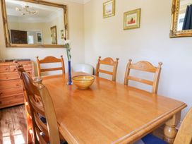 A dining room with a wooden table and chairs at Ty Caredig in Swansea