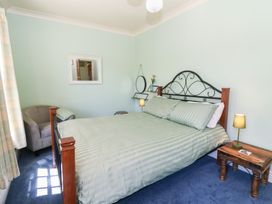 A bedroom with a bed and nightstand at Ty Caredig in Swansea