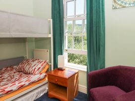 A bedroom with a bunk bed and a bedside table at Ty Caredig Swansea