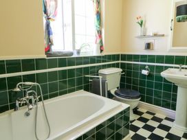 A bathroom with a bathtub, toilet, and sink at Ty Caredig in Swansea