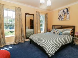 A bedroom with a bed and mirror at Ty Caredig in Swansea