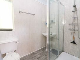 A bathroom with a toilet, sink, and shower at Ty Caredig in Swansea