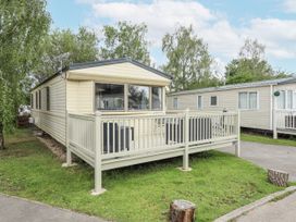 A mobile home with a deck and railing at 31 Castle View in Lincoln