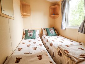A bedroom with two beds and a mirror at 31 Castle View in Lincoln