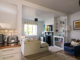 A living room with a television and a sofa at Rockside in Salcombe