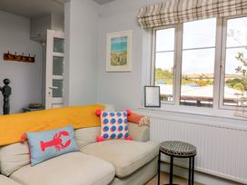 A living room with a sofa and cushions at Rockside in Salcombe