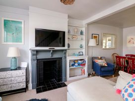 A living room with a television and sofa at Rockside in Salcombe