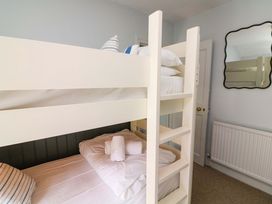 A bedroom with a bunk bed and a mirror at Rockside in Salcombe
