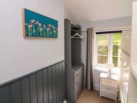 A bedroom with a wardrobe and lamp at Rockside in Salcombe