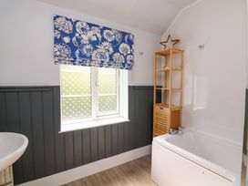 A bathroom with a bathtub and a window at Rockside in Salcombe