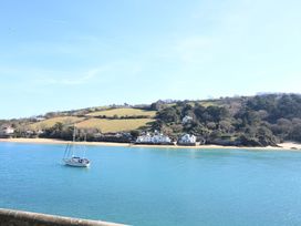 A view of a sailboat on water with houses and hills in the background at Rockside in Salcombe