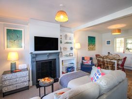 A living room with a television and sofa at Rockside in Salcombe