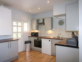 A kitchen with appliances and a door at Rockside in Salcombe