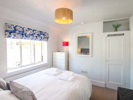 A bedroom with a bed and dresser at Rockside in Salcombe