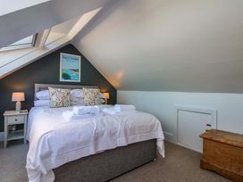 A bedroom with a bed and lamps at Rockside in Salcombe