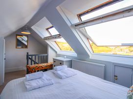 A bedroom with a bed and windows at Rockside in Salcombe