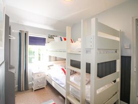 A bedroom with bunk beds and a nightstand at Rockside in Salcombe