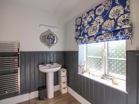 A bathroom with a wash basin and mirror at Rockside in Salcombe