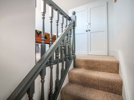 A staircase with a banister leading to closed doors at Rockside in Salcombe