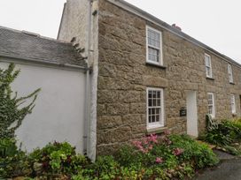 An exterior view of a stone cottage with a garden at 1 Rowes Cottages in Penzance