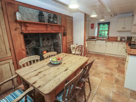 A kitchen with a wooden table and chairs at 1 Rowes Cottages in Penzance
