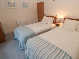 A bedroom with two beds and a lamp at 1 Rowes Cottages Penzance