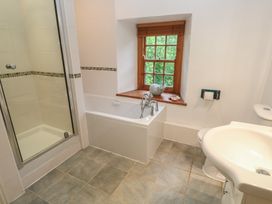 A bathroom with a shower and bathtub at 1 Rowes Cottages in Penzance