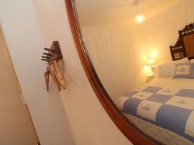 A bedroom with a bed and lamp at 1 Rowes Cottages in Penzance