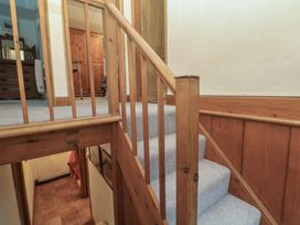 A staircase with wooden railing in a hallway at 1 Rowes Cottages Penzance