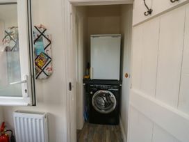 A laundry room with a washing machine and fridge at 13 School Road in Newton Abbot