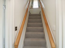 A staircase with a handrail and door at 13 School Road, Newton Abbot